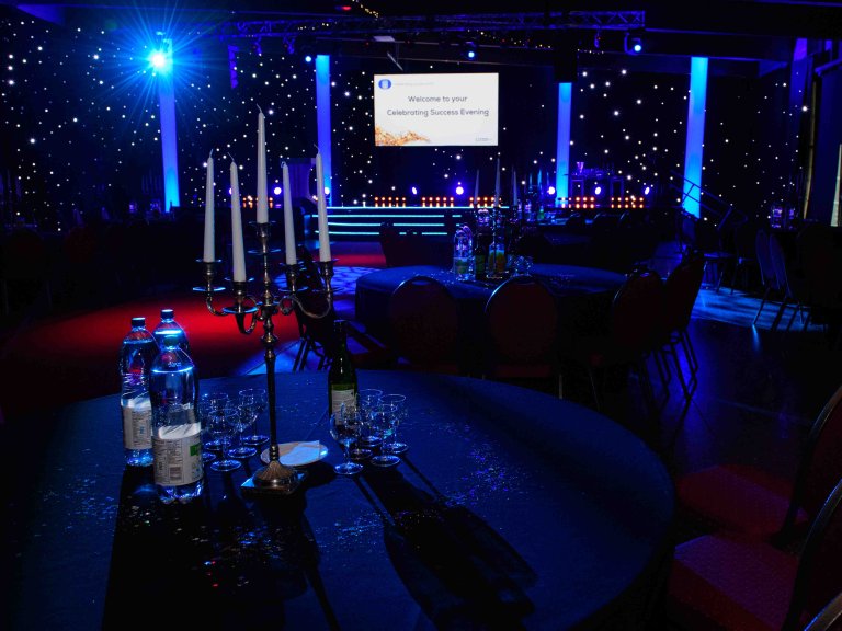 Chris Vaughan Photography - corporate event images | A room set up and lit with blue lighting ahead of an awards ceremony.
