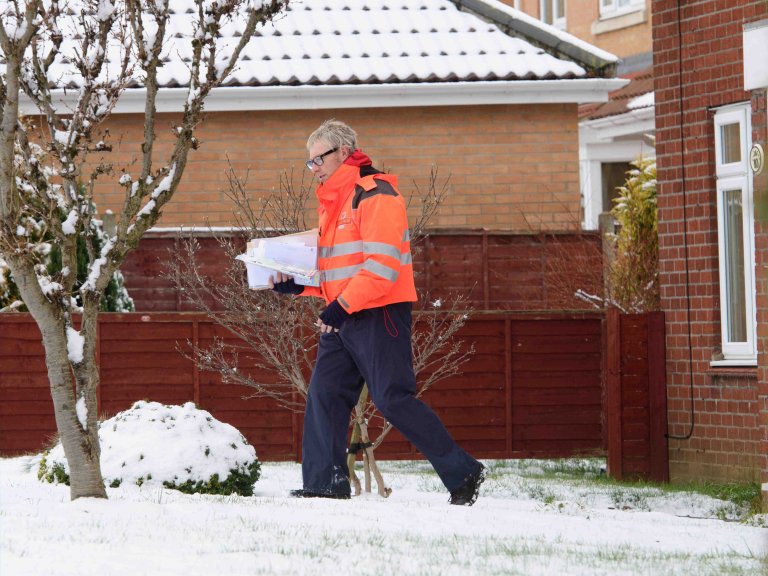 Chris Vaughan Photography - PR and communications images | A postman delivers mail in the snow.