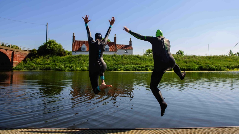 Chris Vaughan Photography - Sports images | Two open water swimmers jump into a river.