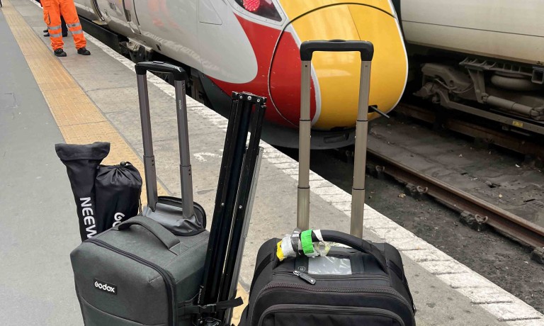 The camera bags belonging to Chris Vaughan Photography on Kings Cross Station with an LNER Azusa train in the background.