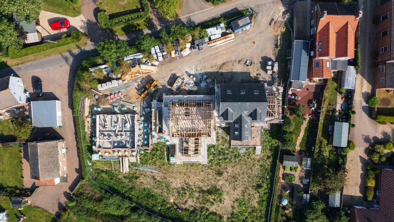 Chris Vaughan Photography - drone images | An aerial top-down image of three residential properties in various stages of construction.