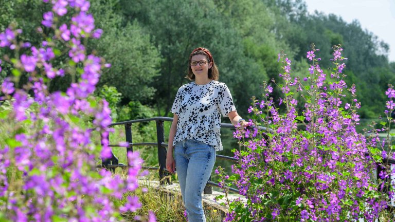 Chris Vaughan Photography - Business profile images | A businesswoman stands surrounded by purple flowers.