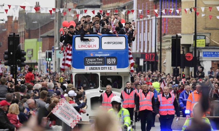 Chris Vaughan Photography - case study: Lincoln City | The players travel on an open top bus through Lincoln's High Street, surrounded by fans, as they celebrate winning the EFL Sky Bet League Two title.