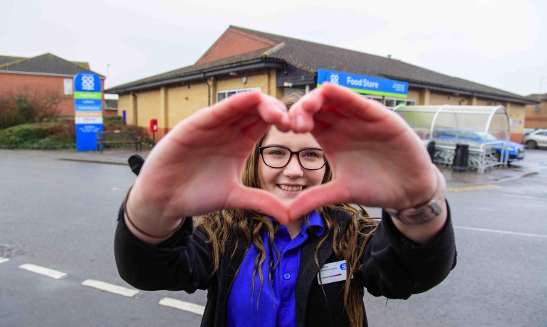 Chris Vaughan Photography - commercial images | A Lincolnshire Co-op colleague makes a heart shape with her hands which frames her face.