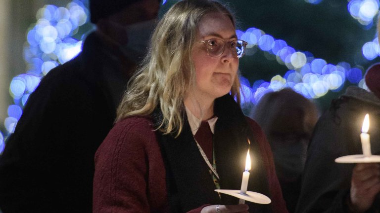 Chris Vaughan - case study images: Lincoln Cathedral | A member of the congratulation holds a candle during a service.
